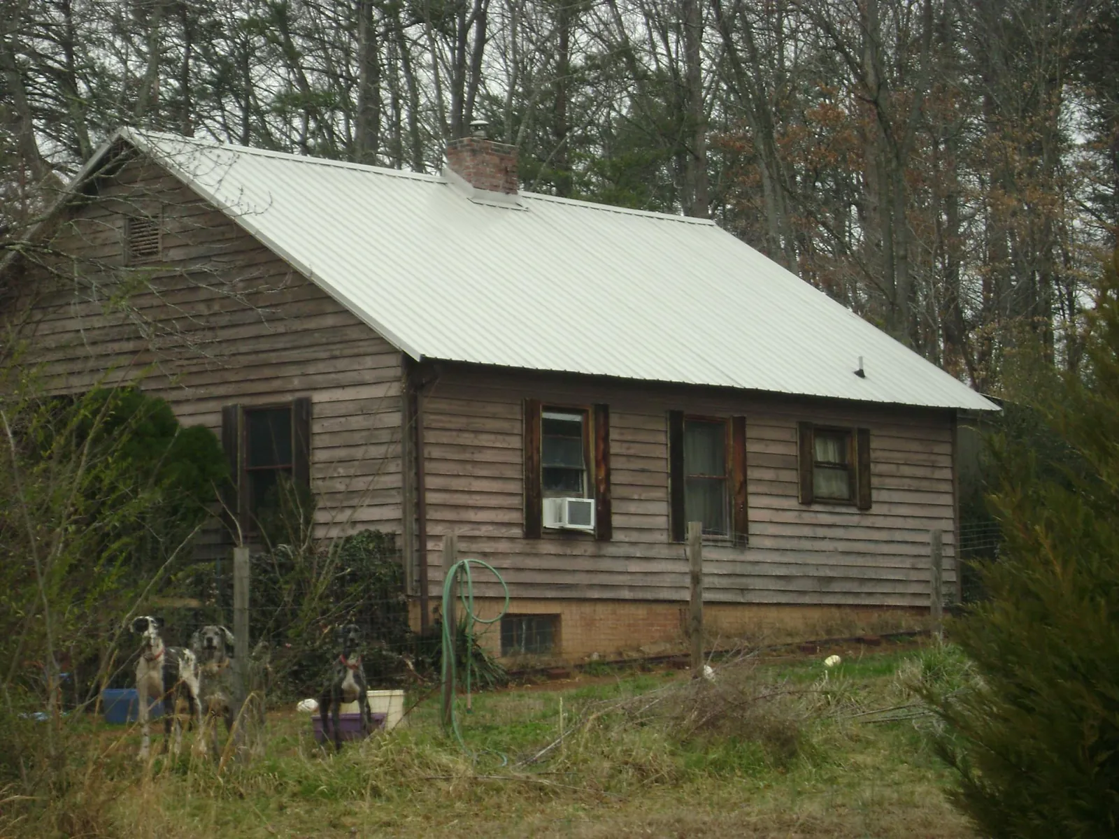 White metal roof on an old wood sided farmhouse, from a Metal Roof Installation job in Roland